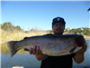 Man in Detroit hat holding large trout
